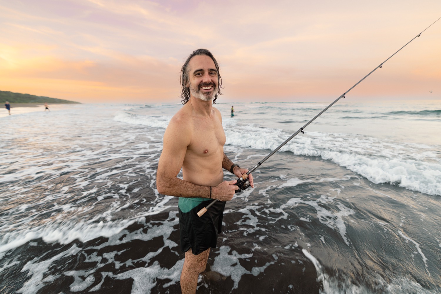 Rob fishing in the surf at sunset