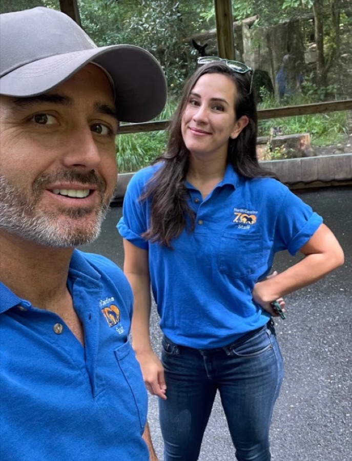 Rob and Haley Nelson in North Carolina Zoo staff shirts outside the gorilla habitat