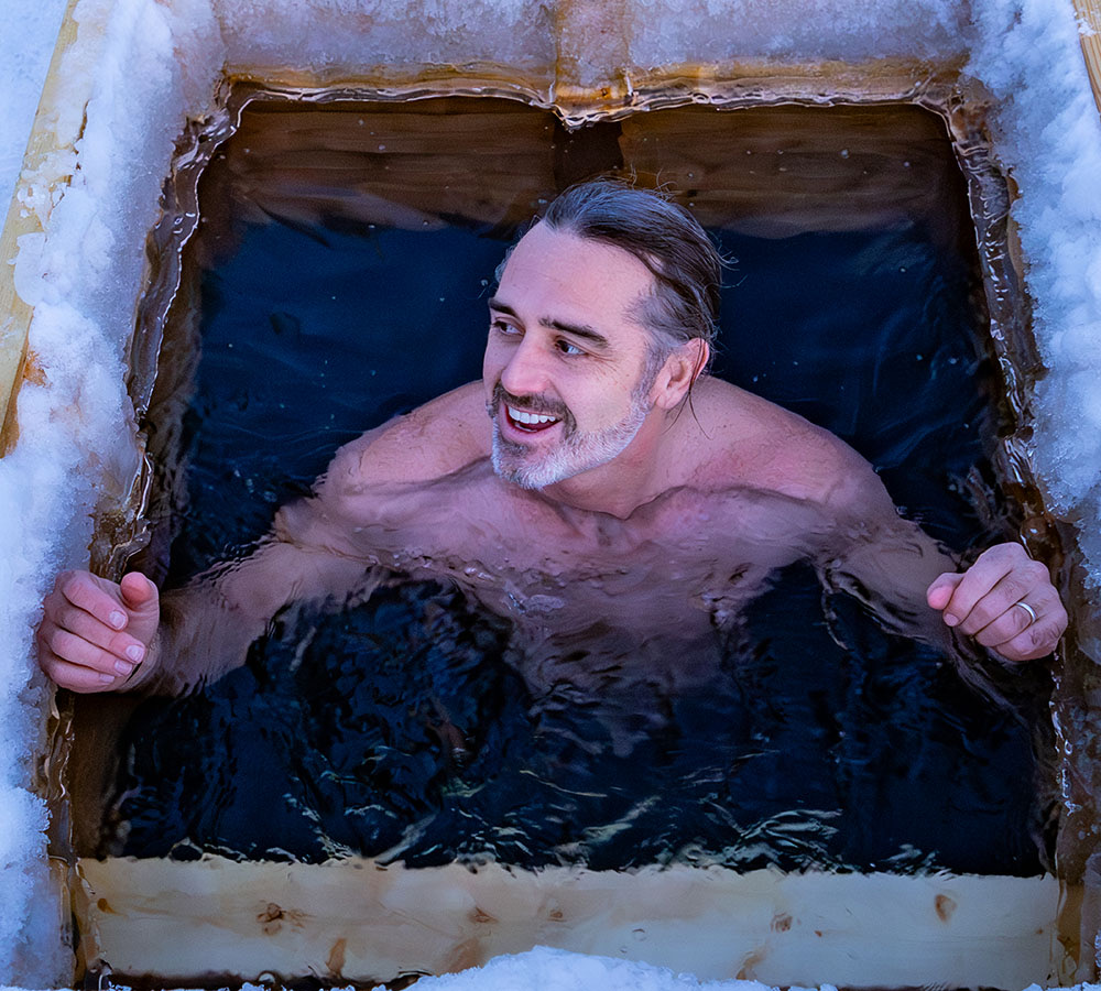 Rob smiling from an ice bath cut into a frozen lake