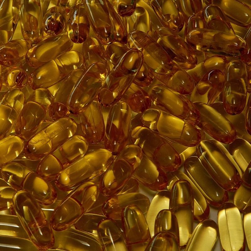 A pile of golden fish oil softgels
