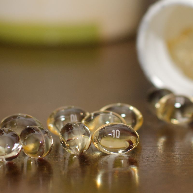 Clear softgel capsules spilling from a bottle